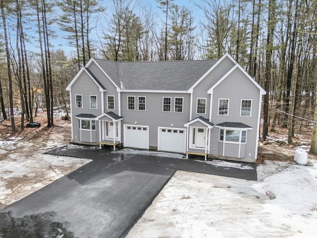 view of front of property featuring aphalt driveway, a shingled roof, and an attached garage