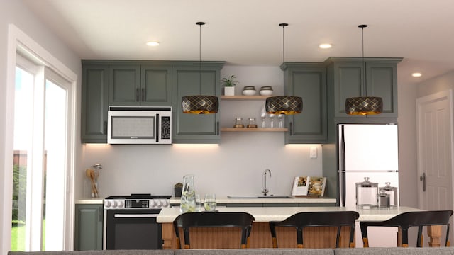 kitchen with decorative light fixtures, stainless steel appliances, a sink, and light countertops