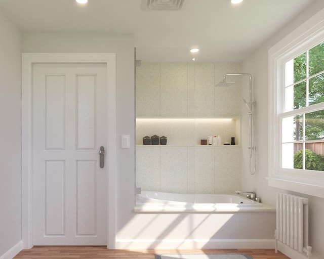 bathroom with radiator heating unit, a tile shower, a bathing tub, and recessed lighting