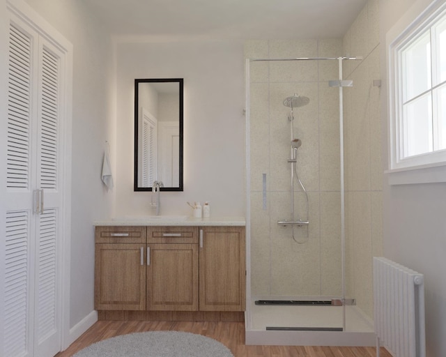 full bath featuring a stall shower, a closet, vanity, and radiator