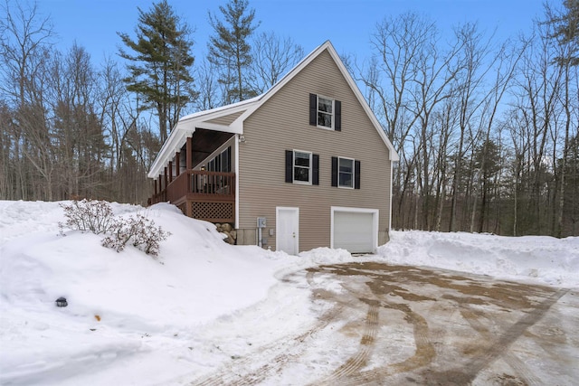 view of snow covered exterior with a garage