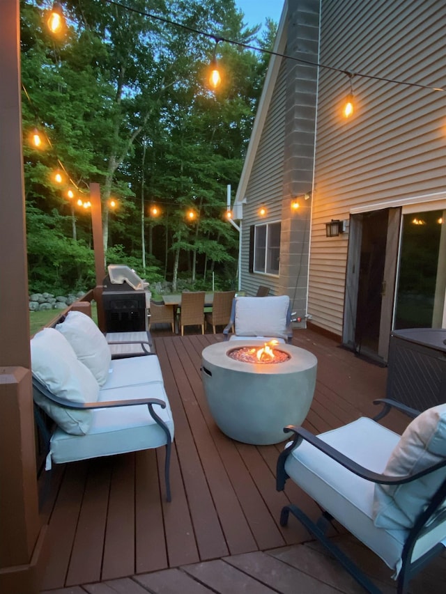 deck with a fire pit and a grill