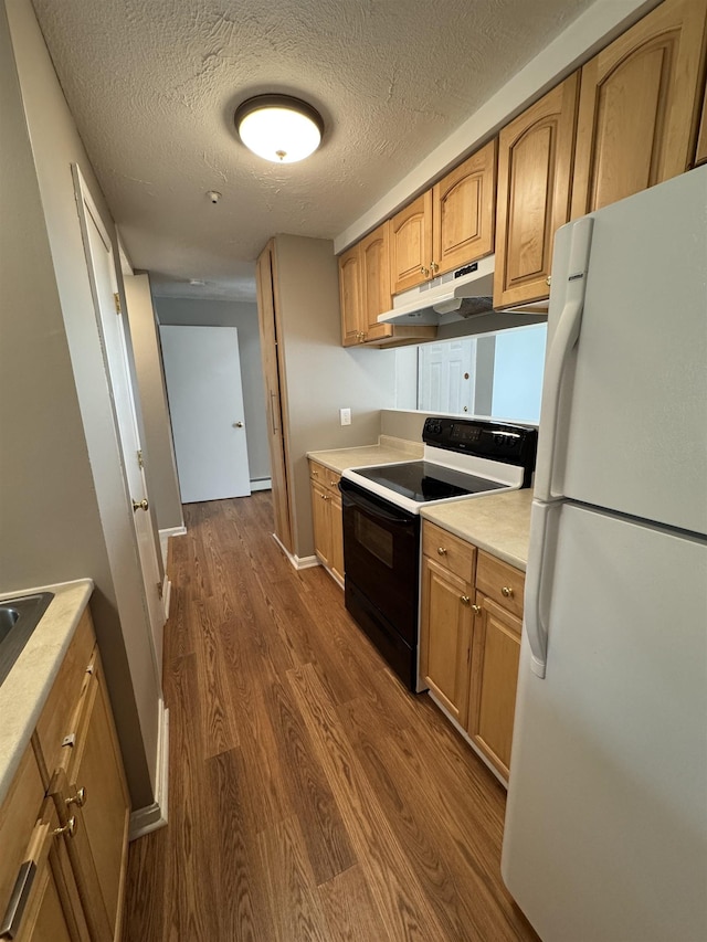 kitchen with under cabinet range hood, electric stove, dark wood finished floors, and freestanding refrigerator