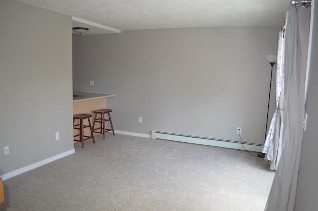 unfurnished room featuring baseboard heating, baseboards, and carpet floors