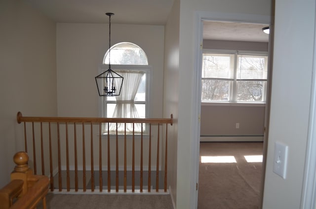 staircase with a baseboard radiator, plenty of natural light, carpet, and a notable chandelier