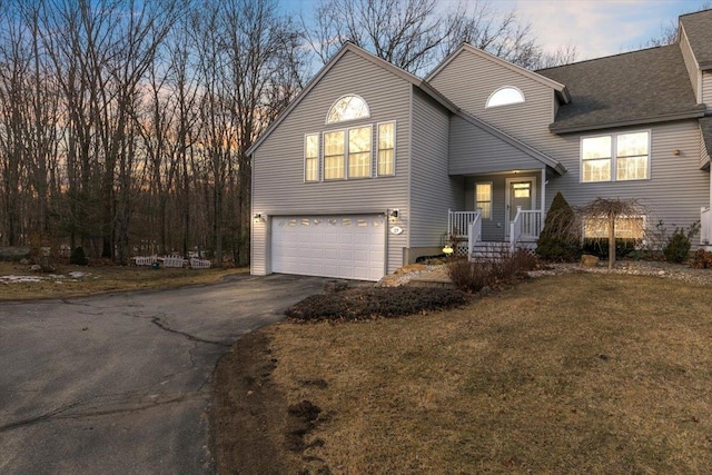 view of front of property featuring aphalt driveway, a front lawn, a garage, and roof with shingles