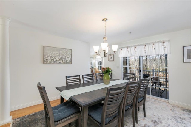 dining area featuring baseboards, light wood-type flooring, and a chandelier