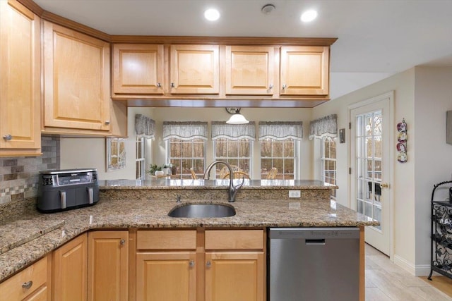 kitchen with a sink, stainless steel dishwasher, a peninsula, decorative backsplash, and light stone countertops