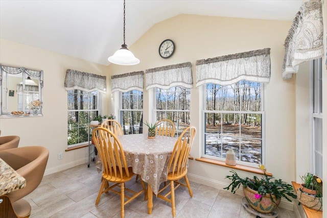 dining space with tile patterned floors, baseboards, and lofted ceiling