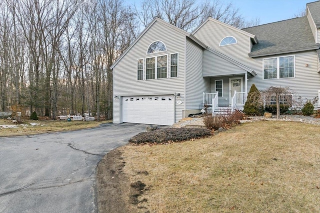 view of front of home with driveway, a front lawn, a garage, and roof with shingles