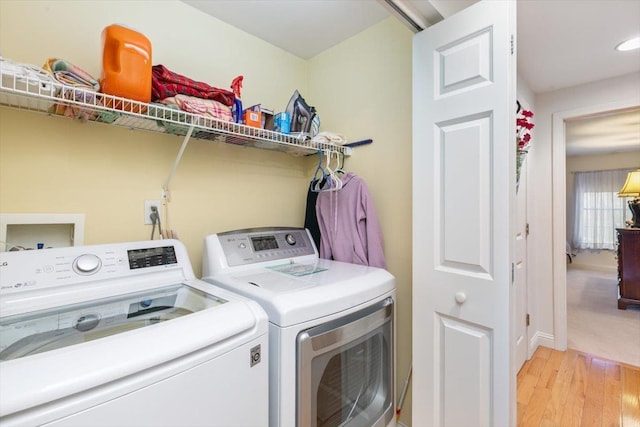 laundry area featuring light wood-type flooring, washing machine and dryer, and laundry area