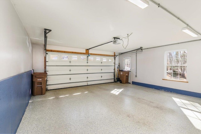 garage with a garage door opener and baseboards