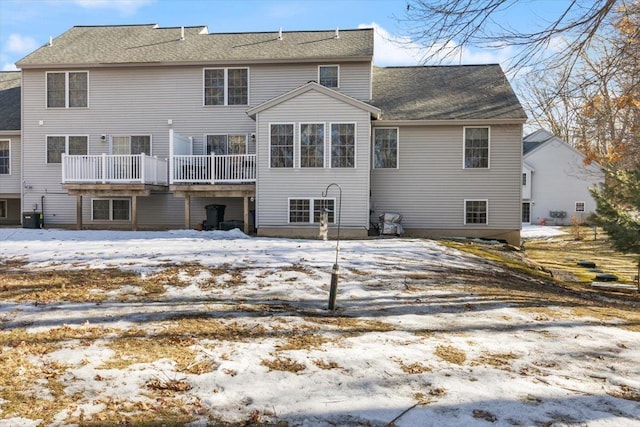 snow covered property with a wooden deck