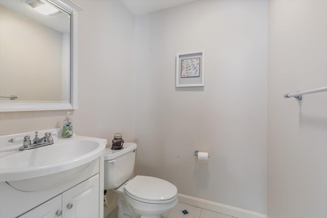 bathroom with baseboards, toilet, vanity, and tile patterned flooring