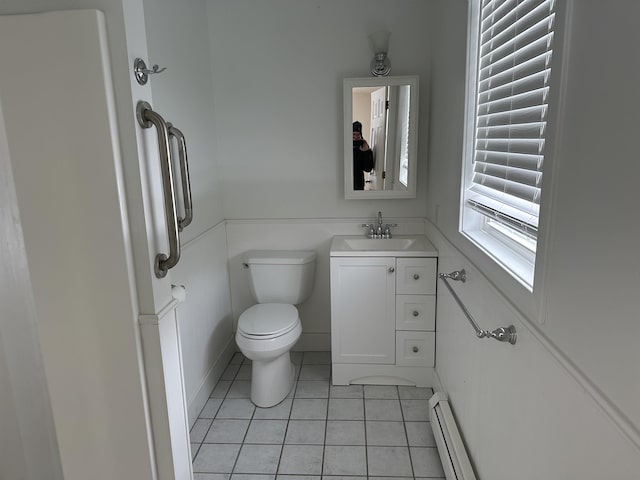 half bath with vanity, tile patterned floors, toilet, and baseboard heating