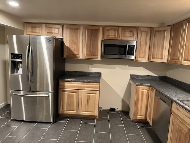 kitchen with dark countertops, wood finish floors, and stainless steel appliances