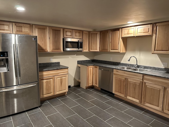 kitchen featuring dark countertops, stainless steel appliances, and a sink