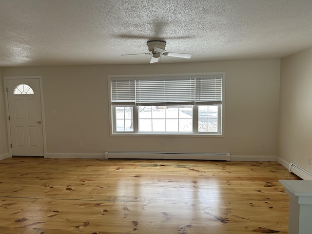 entryway featuring a baseboard heating unit, baseboards, light wood-style floors, and a ceiling fan