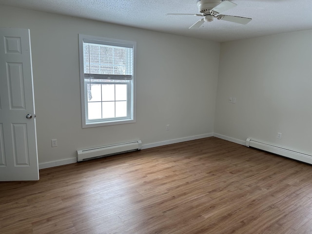 empty room featuring ceiling fan, a baseboard radiator, a textured ceiling, and wood finished floors