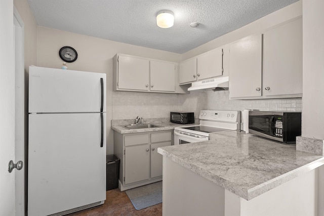 kitchen with white appliances, a peninsula, a sink, light countertops, and under cabinet range hood