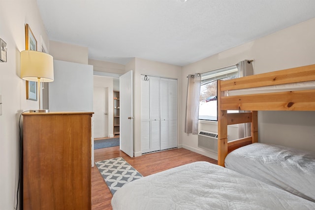 bedroom with a closet, baseboards, and wood finished floors