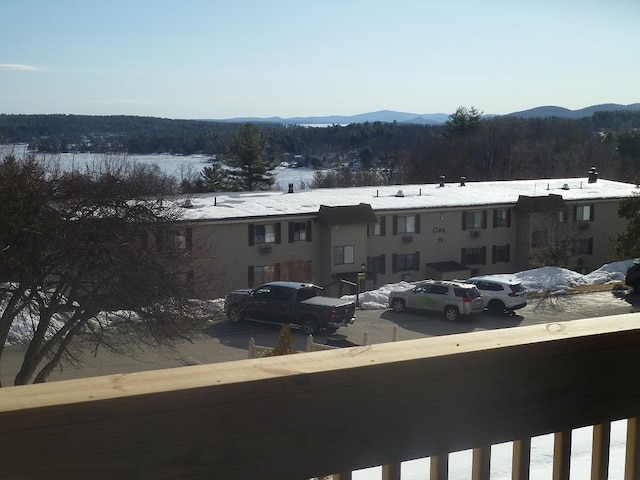 snow covered back of property featuring a mountain view