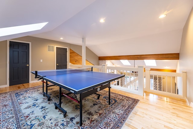 game room featuring wood finished floors, visible vents, baseboards, vaulted ceiling with skylight, and recessed lighting