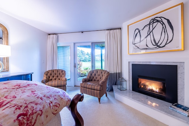 bedroom with access to exterior, a fireplace, and carpet floors