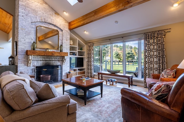 living area featuring a brick fireplace, built in shelves, beam ceiling, a skylight, and high vaulted ceiling