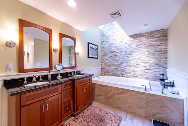 full bath featuring a garden tub, double vanity, visible vents, and a sink