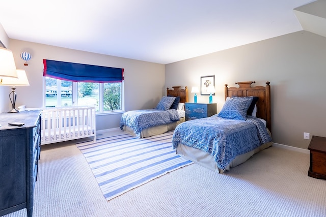 bedroom featuring baseboards, carpet, and vaulted ceiling