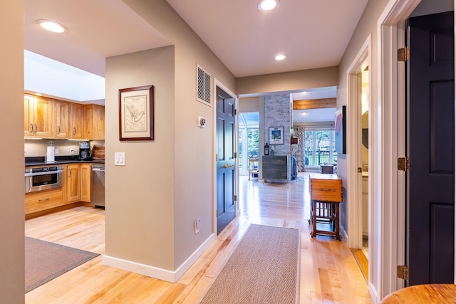 corridor with visible vents, light wood-style flooring, recessed lighting, and baseboards