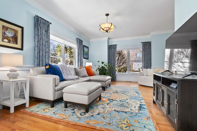 living area featuring light wood-type flooring and crown molding