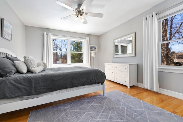 bedroom with wood finished floors, baseboards, and ceiling fan