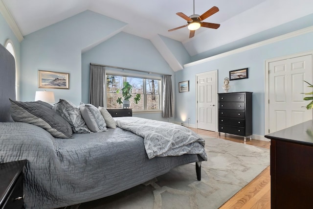 bedroom with baseboards, lofted ceiling, a ceiling fan, and light wood finished floors