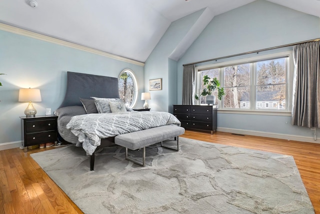 bedroom with vaulted ceiling, visible vents, baseboards, and wood finished floors