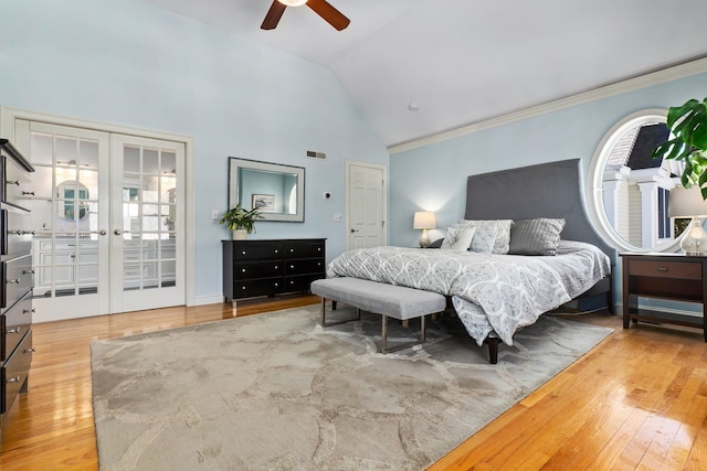 bedroom featuring high vaulted ceiling, ornamental molding, hardwood / wood-style flooring, french doors, and ceiling fan