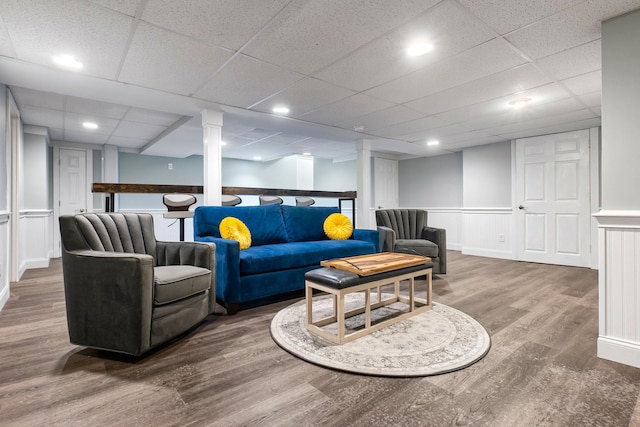 living area with recessed lighting, a wainscoted wall, a paneled ceiling, and wood finished floors