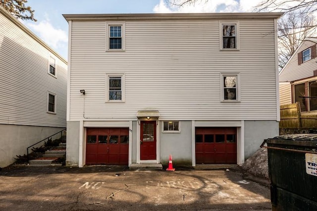 rear view of property with a garage and driveway