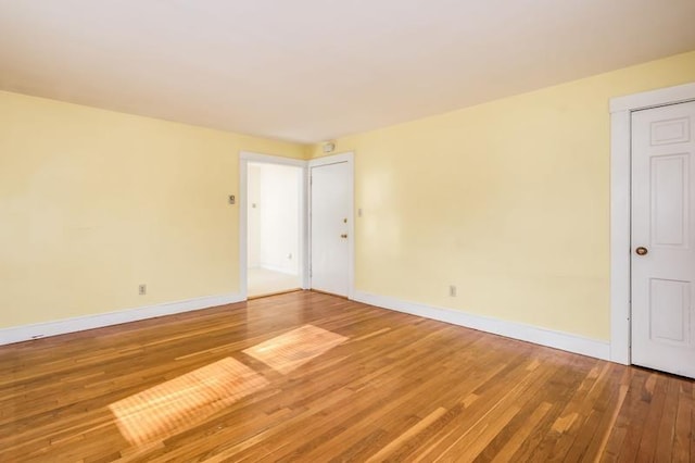 unfurnished room with hardwood / wood-style flooring and baseboards