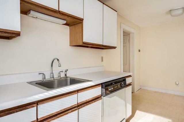 kitchen featuring light floors, white cabinetry, a sink, light countertops, and dishwasher