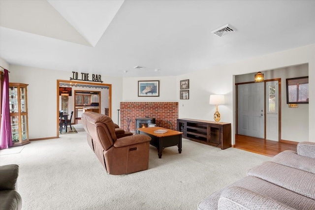 carpeted living area with lofted ceiling, baseboards, and visible vents