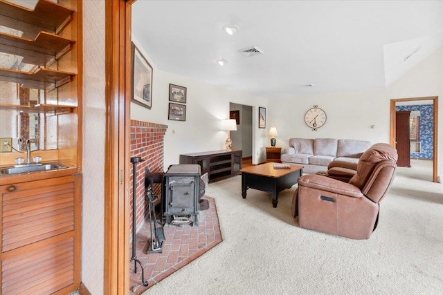 living room with visible vents, a wood stove, and carpet