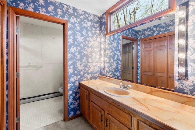 bathroom featuring wallpapered walls, vanity, and a baseboard heating unit