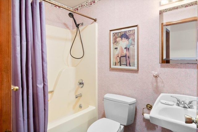 bathroom featuring shower / tub combo, toilet, and a sink