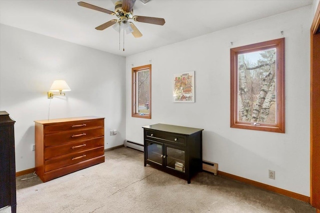 interior space featuring carpet flooring, a ceiling fan, a baseboard heating unit, and baseboards