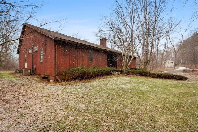 view of side of property featuring a yard and a chimney