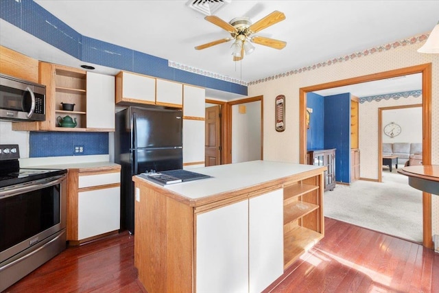 kitchen with wallpapered walls, open shelves, stainless steel appliances, light countertops, and dark wood-type flooring