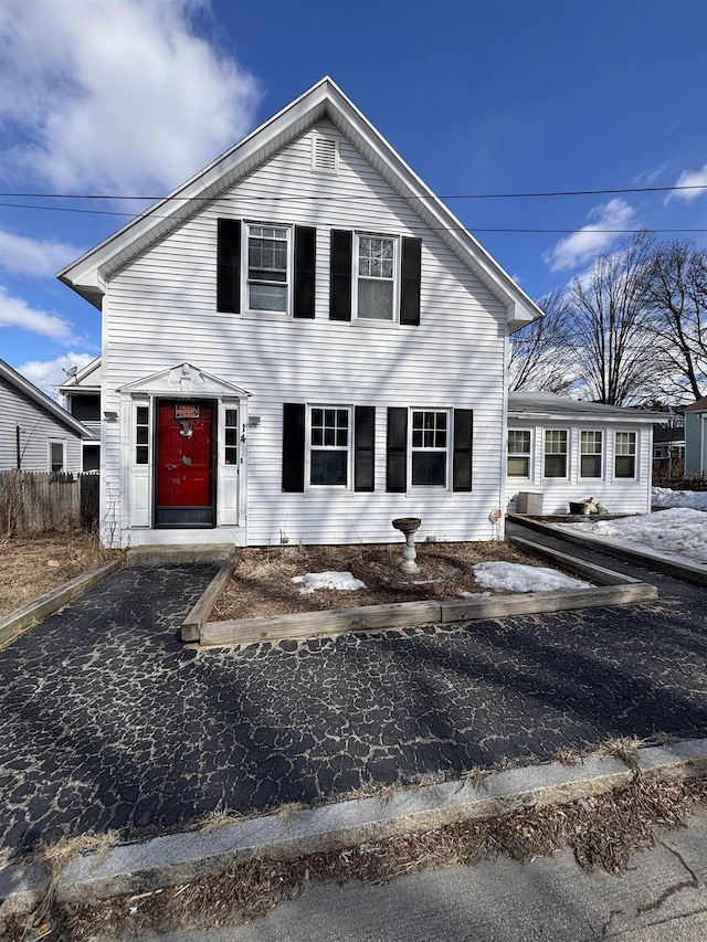 traditional home featuring driveway and fence