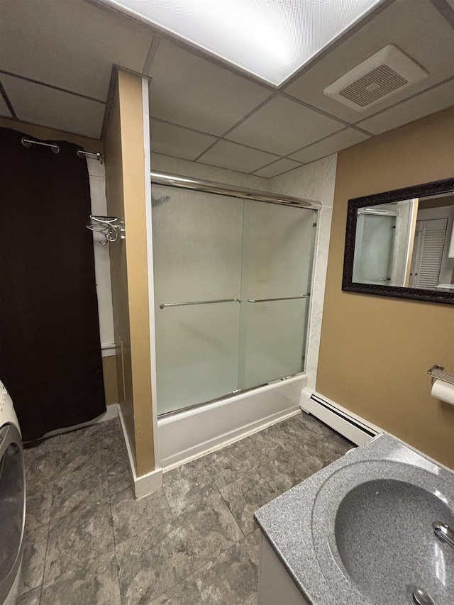 bathroom featuring vanity, visible vents, enclosed tub / shower combo, a paneled ceiling, and a baseboard heating unit